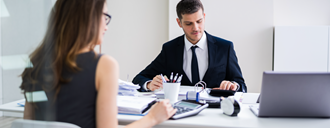 Two people face each other working at a desk